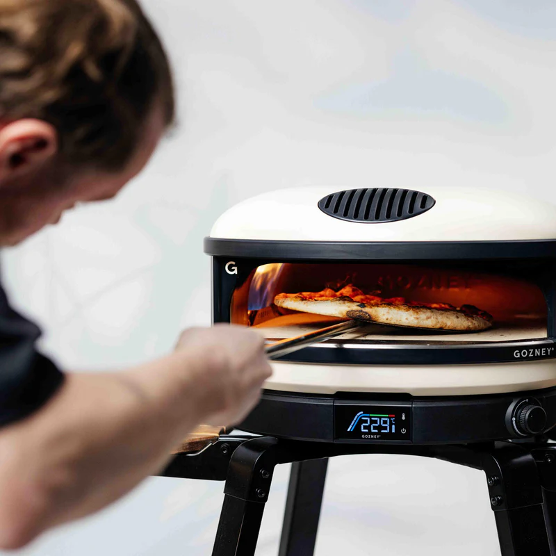 Gozney Arc Pizza Oven — pizza on peel being launched into oven
