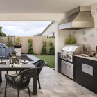 Trade-Wind 48" Pyramid BBQ Wall Hood w/ Extended Duct Cover installed above a built-in grill in an outdoor kitchen