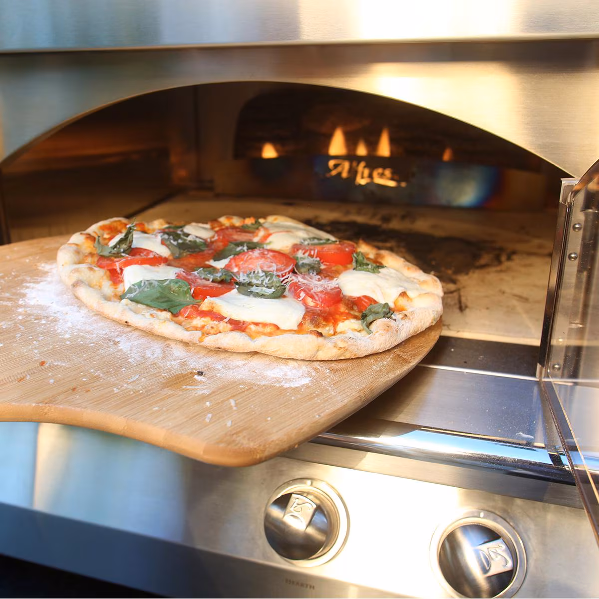 Freshly baked pizza inside the Alfresco 30-Inch Countertop Pizza Oven at a Smoky Stone outdoor kitchen in Naples, FL